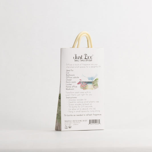 Just Bee Rockrose de la Mer Small-Space Hanging Diffuser, angled back of the pack with a painted coastal scene.