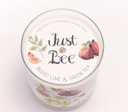 Just Bee Blood Lime & Green Tea candle from above, round lid label with blood limes and a centered wick.