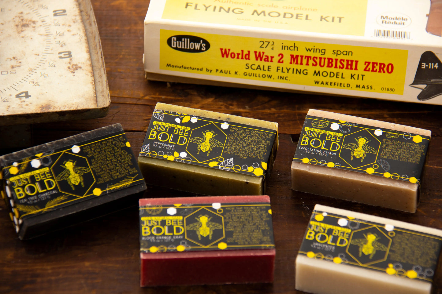 A collection of colorful soap bars arranged on a wooden surface next to a World War 2 model kit.