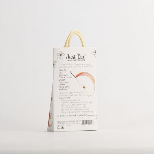 Just Bee Apple Harvest Small-Space Hanging Diffuser, angled back of the pack with a peeled apple and blossoms.