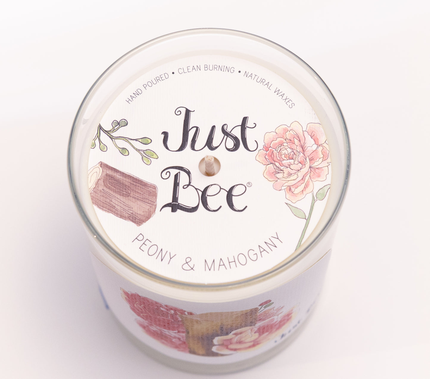 Just Bee Peony & Mahogany candle from above, round lid label with a pink peony and a centered wick.