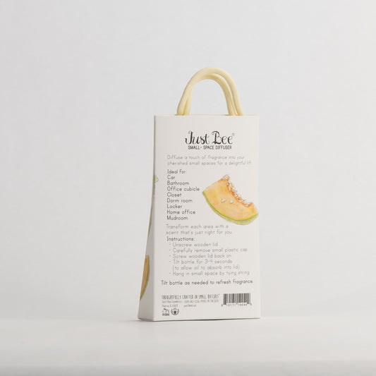 Just Bee Persian Melon & Rosemary Small-Space Hanging Diffuser, angled back of the pack with a cut melon wedge.
