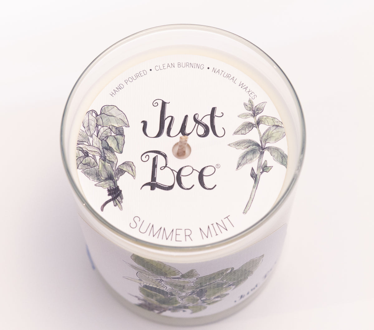 Just Bee Summer Mint candle from above, round lid label with mint leaves and a centered wick.