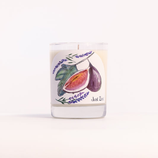 Just Bee Lavender Fig candle in a clear glass jar illustrated with halved purple figs and lavender.