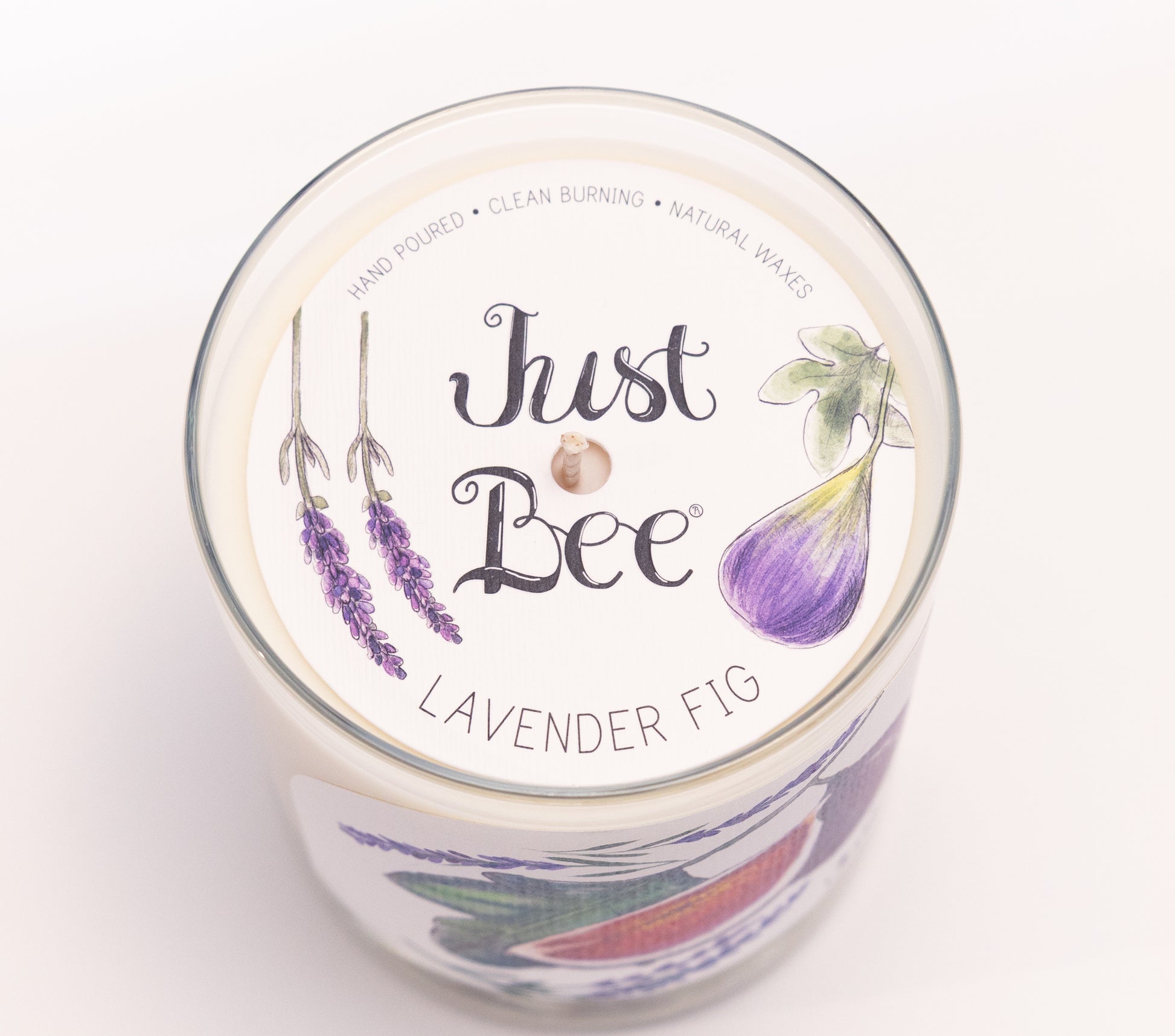 Just Bee Lavender Fig candle from above, round lid label with figs, lavender sprigs and a centered wick.