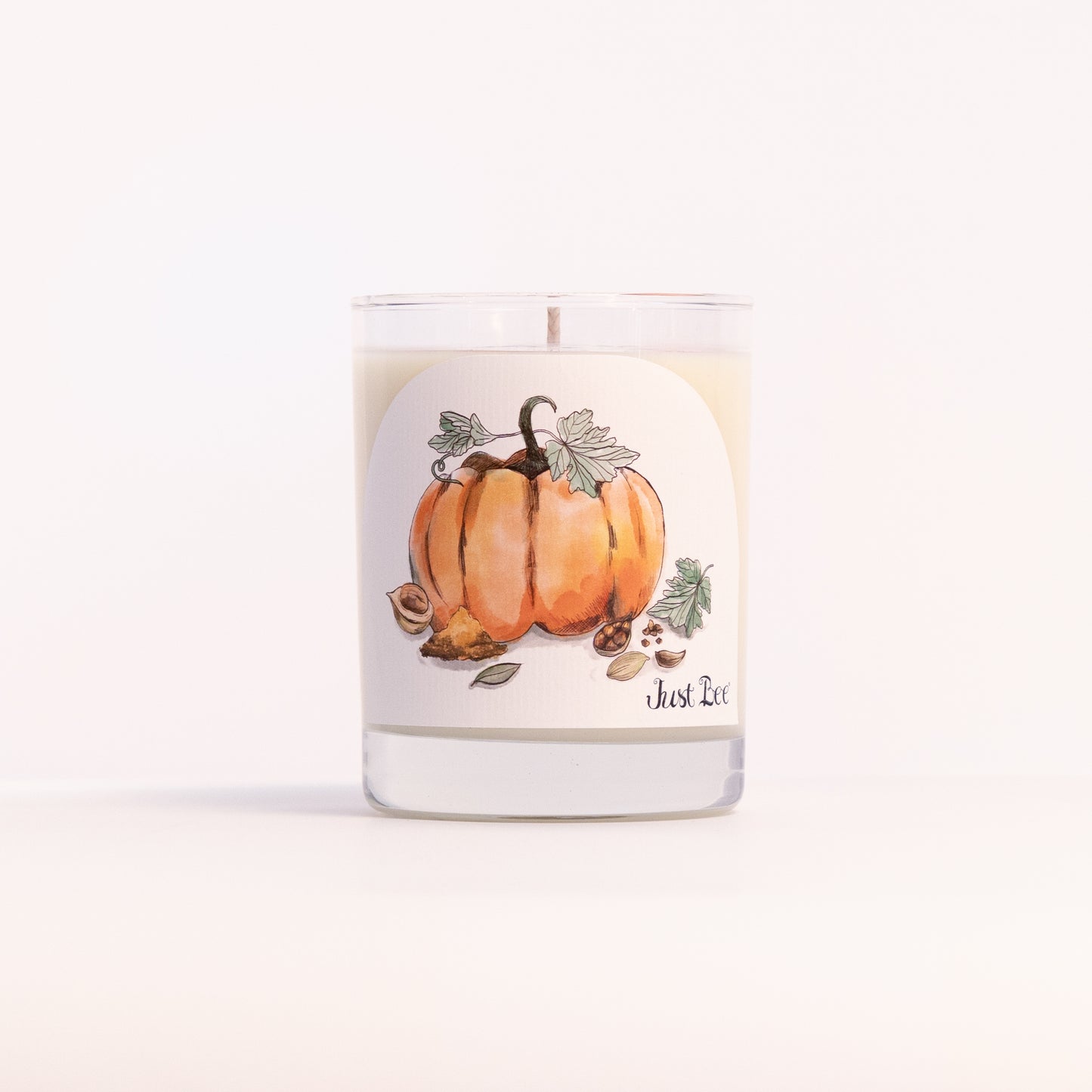 Just Bee Spiced Pumpkin candle in a clear glass jar illustrated with orange pumpkins, vines and leaves.
