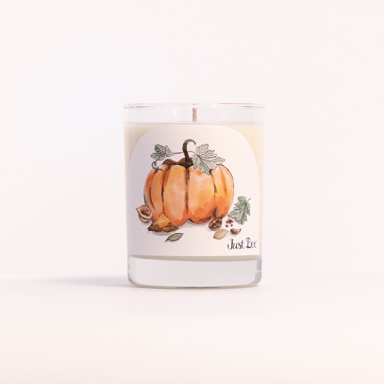 Just Bee Spiced Pumpkin candle in a clear glass jar illustrated with orange pumpkins, vines and leaves.