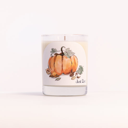Just Bee Spiced Pumpkin candle in a clear glass jar illustrated with orange pumpkins, vines and leaves.