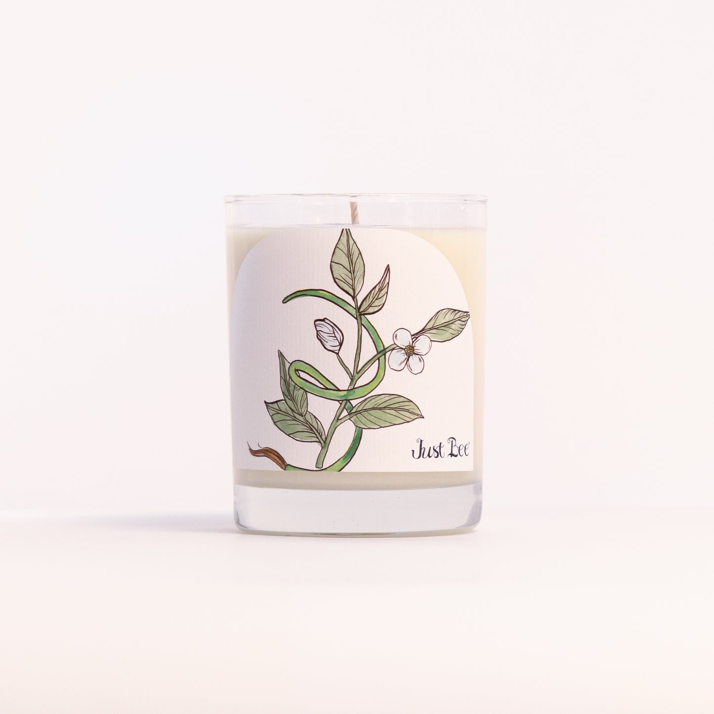 Just Bee Black Tea & Vetiver candle in a clear glass jar with a green tea leaf and bud illustration.