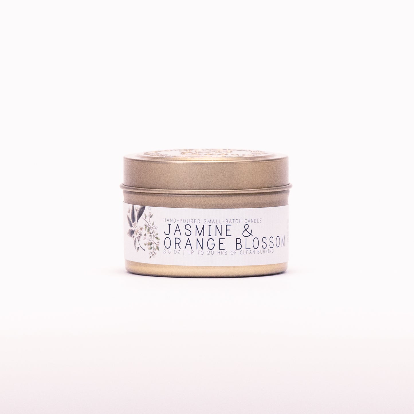 Just Bee Jasmine & Orange Blossom candle in a closed gold travel tin, white blossom label facing forward.