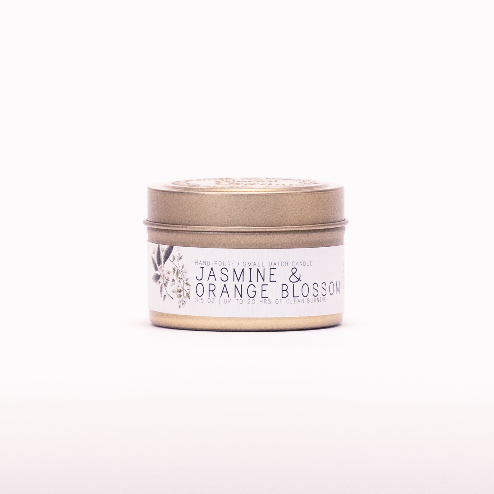 Just Bee Jasmine & Orange Blossom candle in a closed gold travel tin, white blossom label facing forward.