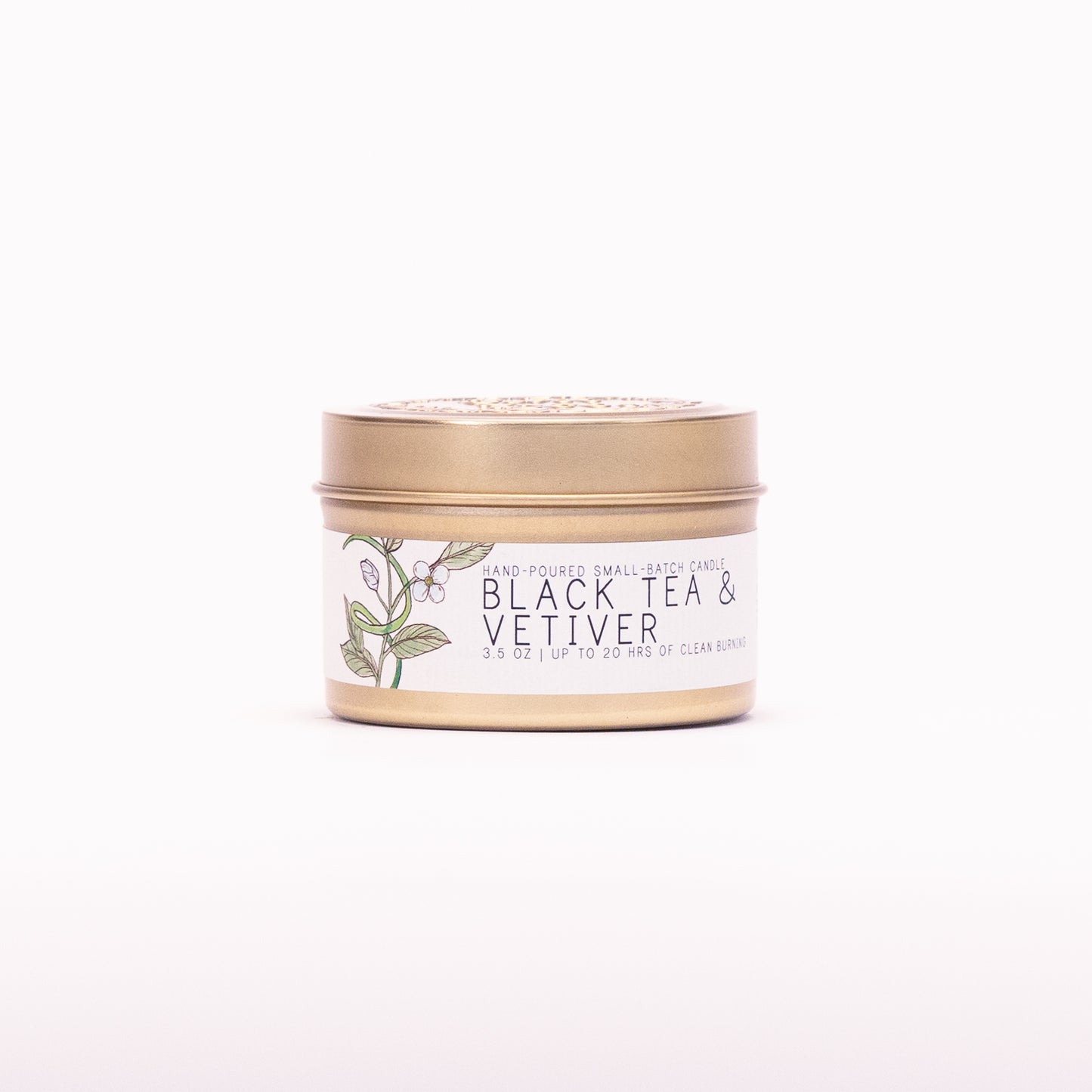 Just Bee Black Tea & Vetiver candle in a closed gold travel tin, tea leaf label facing forward.