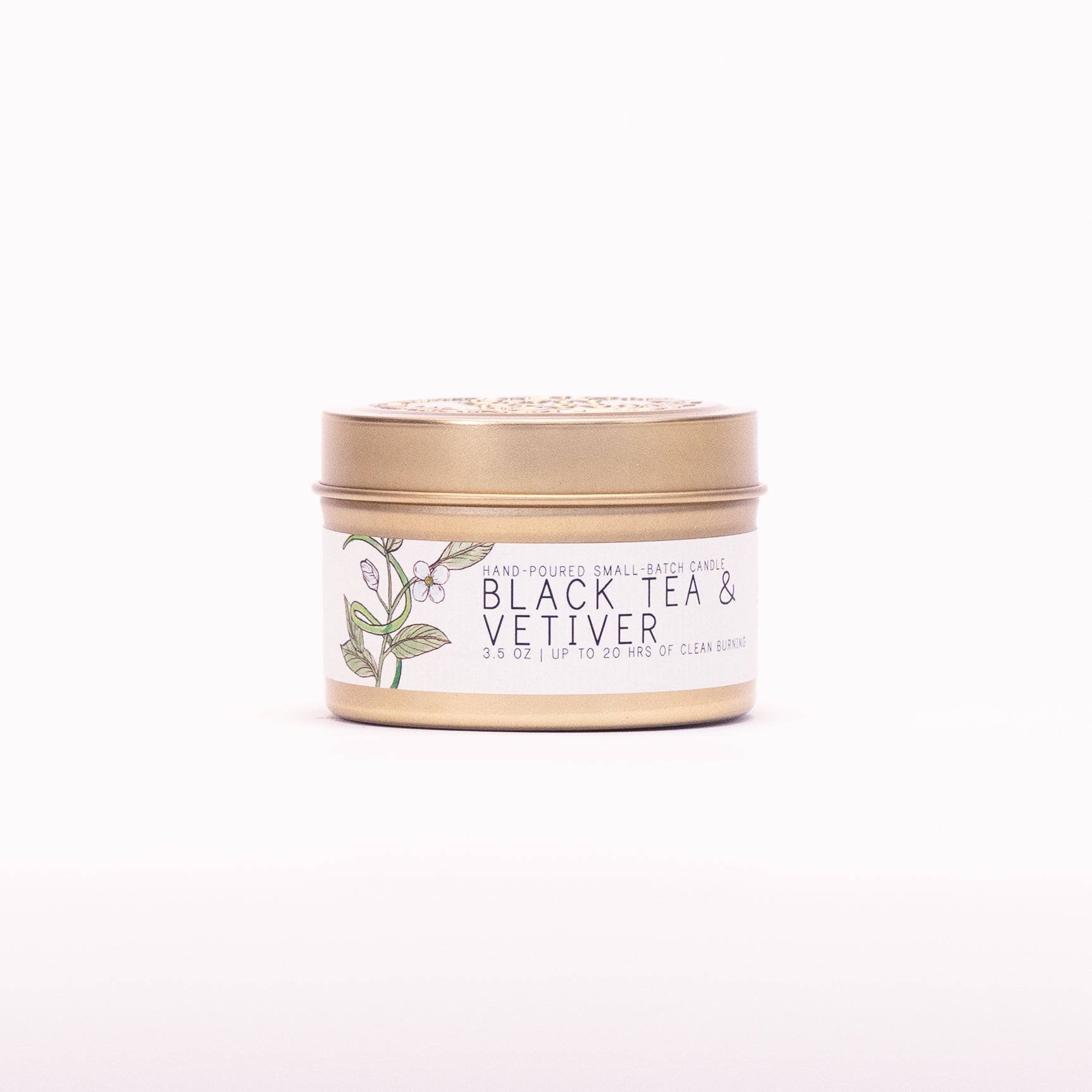 Just Bee Black Tea & Vetiver candle in a closed gold travel tin, tea leaf label facing forward.