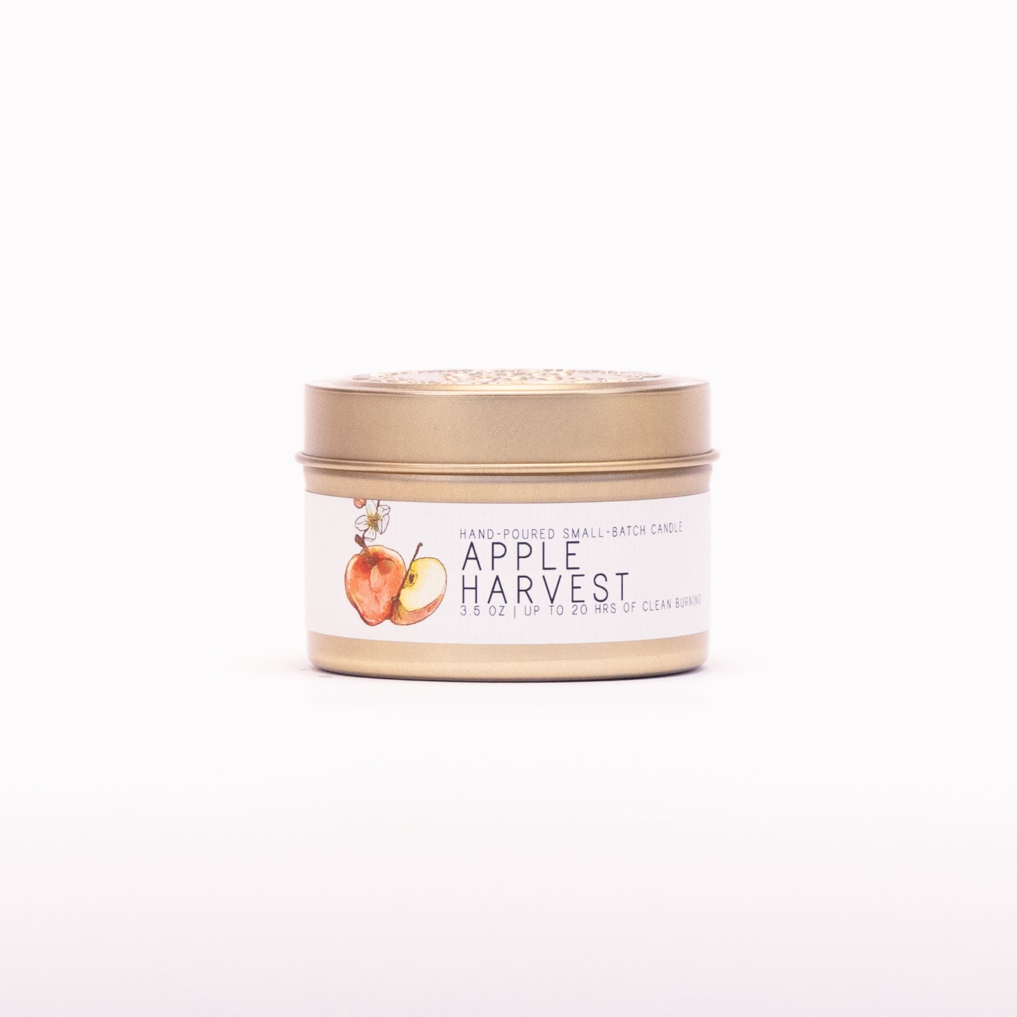 Just Bee Apple Harvest candle in a closed gold travel tin, red apple label facing forward.
