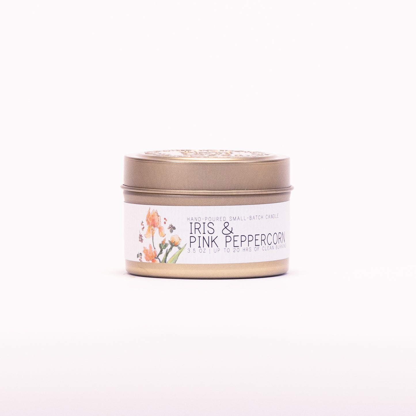 Just Bee Iris & Pink Peppercorn candle in a closed gold travel tin, iris label facing forward.