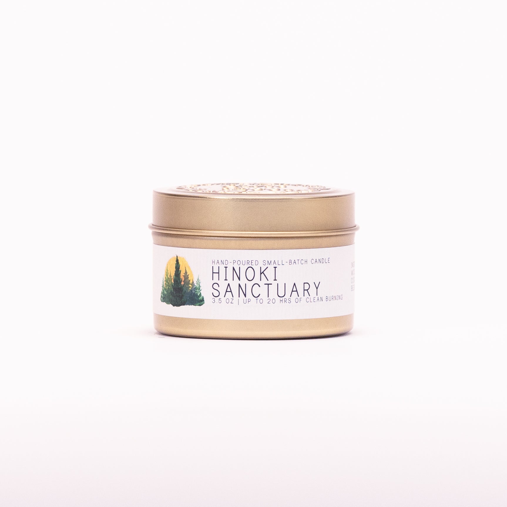 Just Bee Hinoki Sanctuary candle in a closed gold travel tin, evergreen pine label facing forward.
