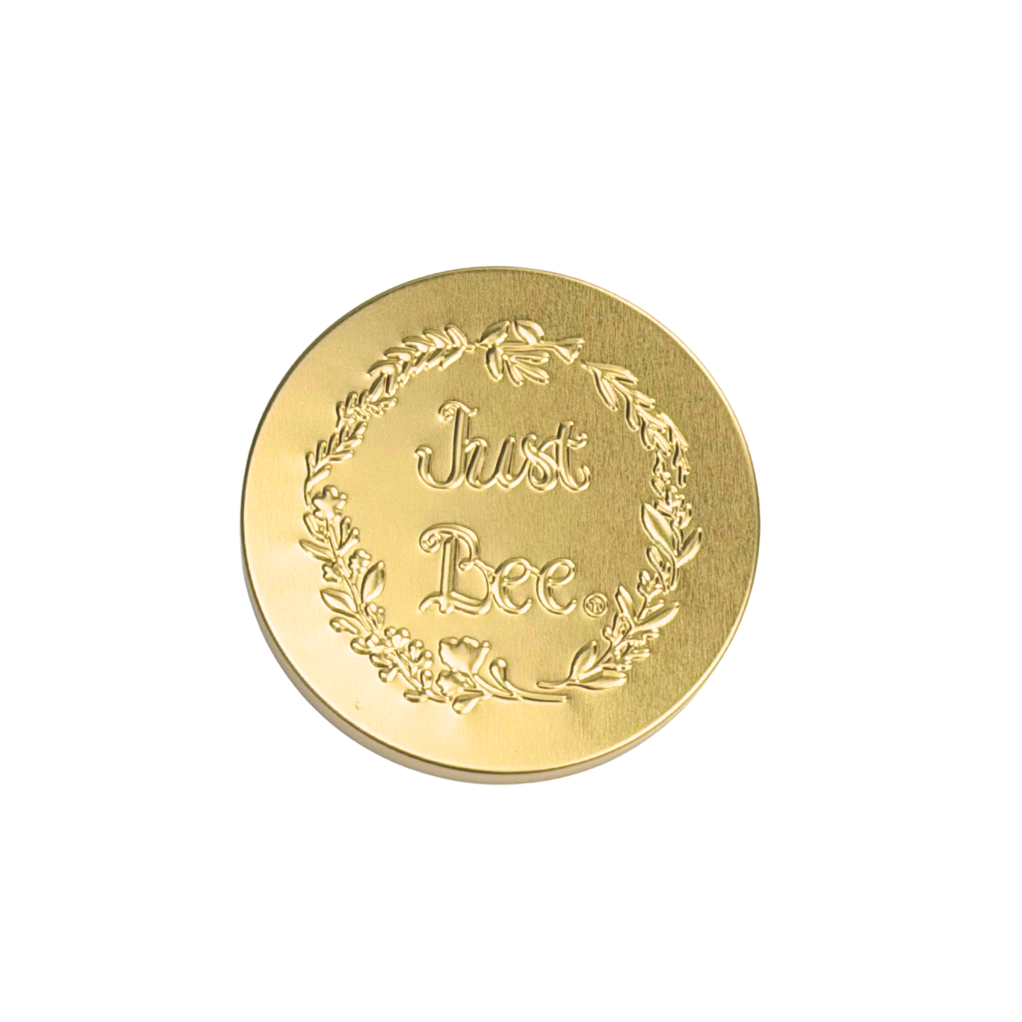 A decorative gold coin with the engraved phrase 'Just Bee' surrounded by a floral wreath.