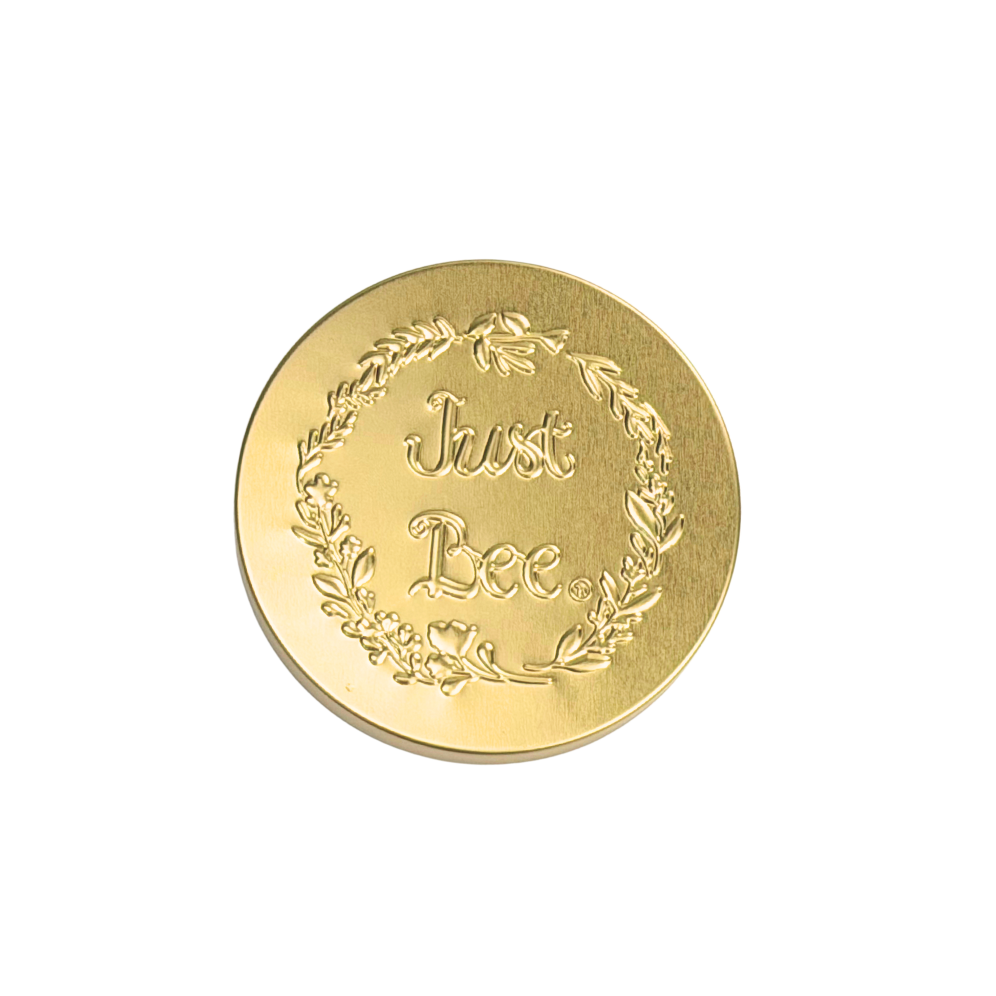 A decorative gold coin with the engraved phrase 'Just Bee' surrounded by a floral wreath.